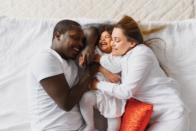 Héhé, jouant au lit avec leur fille