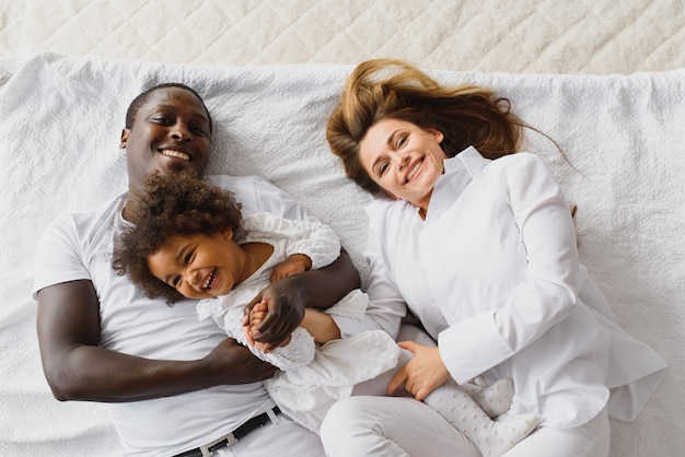 Héhé, jouant au lit avec leur fille