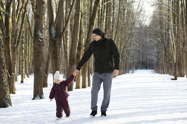 Héhé jouant et riant en hiver à l'extérieur dans la neige. Journée d'hiver du parc de la ville.