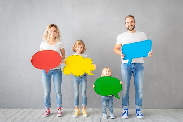 Héhé - père, mère, fille et fils - tenant vide de bulle de dialogue papier coloré