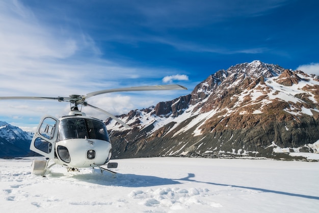 Hélicoptère atterrissant sur la montagne de neige dans le glacier tasman à Mt Cook, en Nouvelle-Zélande.