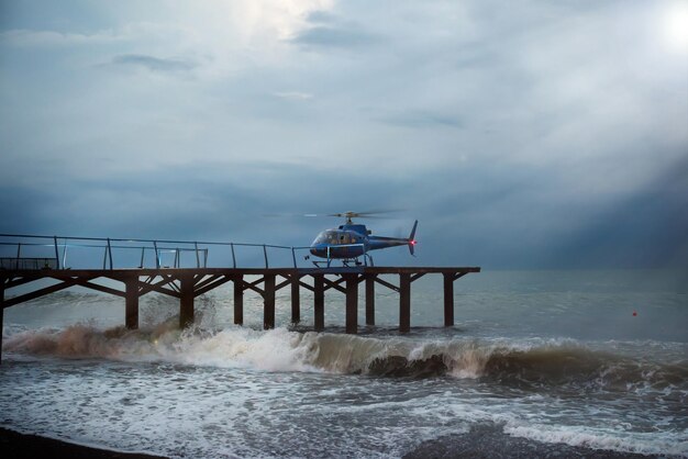 Photo un hélicoptère atterrit des gens pendant une tempête marine hélicopter de patrouille de tempête