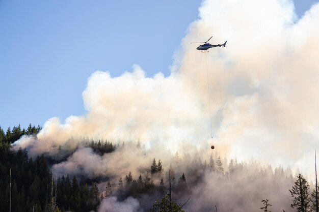 Hélicoptère combattant les incendies de forêt en Colombie-Britannique au cours d'une chaude journée d'été ensoleillée