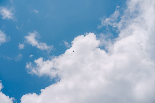 L'hélicoptère de passagers vole dans le ciel parmi les nuages