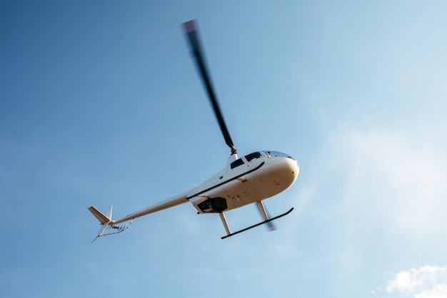 Photo un hélicoptère vole dans le ciel.