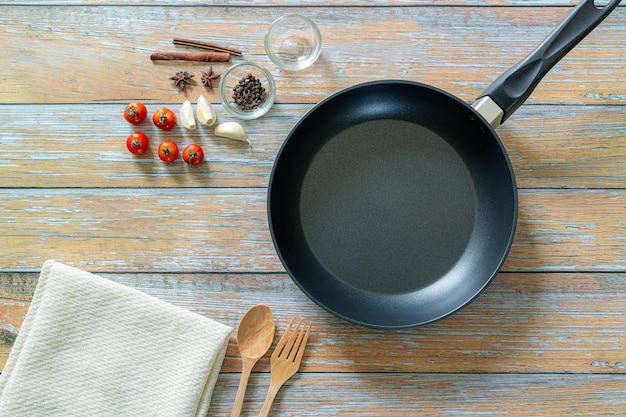 herbes et épices autour d'une poêle en fonte sur fond de bois Concept de cuisson