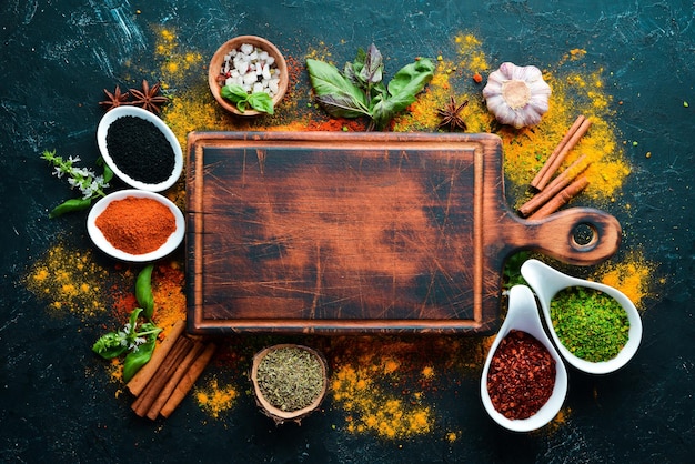 Herbes et épices colorées pour la cuisson des épices indiennes Sur fond de pierre noire Vue de dessus