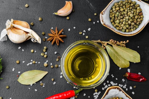 Herbes et épices à l'huile d'olive sur fond noir