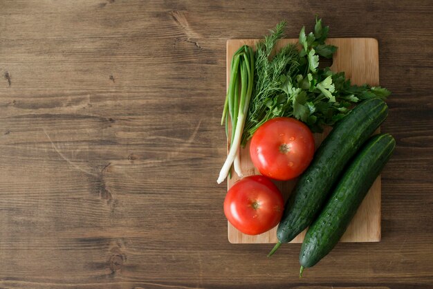 Herbes fraîches et légumes sur une table en bois