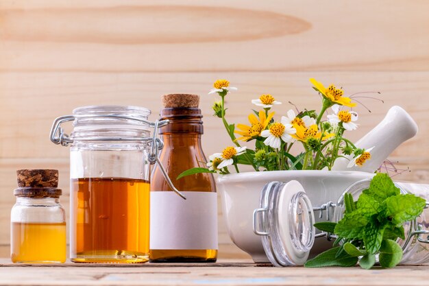 Herbes fraîches de soins de santé alternatifs avec du mortier sur fond de bois.