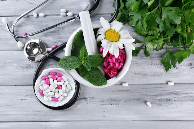 Photo herbes de médecine alternative et stéthoscope sur fond de table en bois