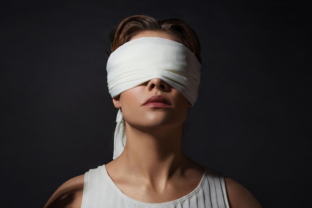 Photo une héroïne antique a bandé les yeux d'une jeune femme dans une tunique avec un bandeau sur les yeux un gros plan contrastant portr