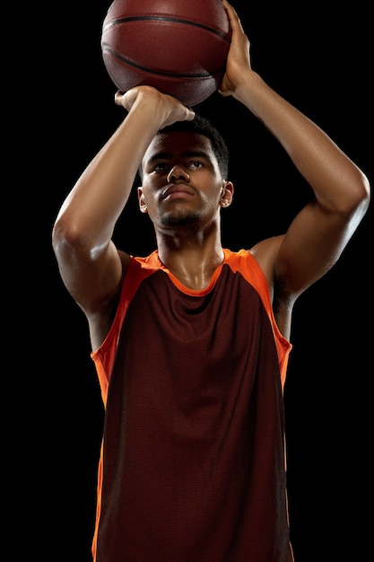 Photo héros jeune joueur de basket-ball afro-américain déterminé s'entraînant en action