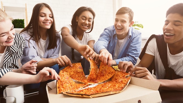 Heure de la collation Étudiants heureux mangeant de la pizza et bavardant