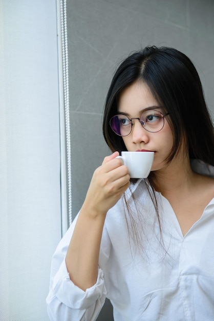 L'heure du café de la femme de bureau porte des lunettes au bureau