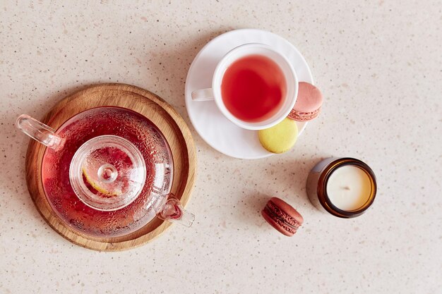 L'heure du thé d'automne avec une tasse de thé théière en verre et des macarons Thé naturel aux fruits de framboise aux herbes