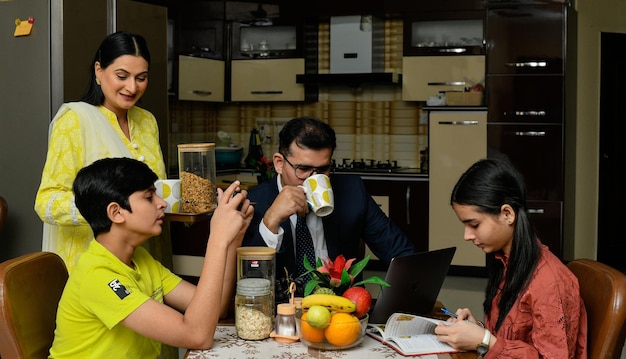 Heure du thé en famille heureuse assis sur une table à manger modèle pakistanais indien