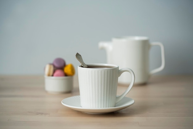 L'heure du thé Tasse de thé avec une théière et un macaron