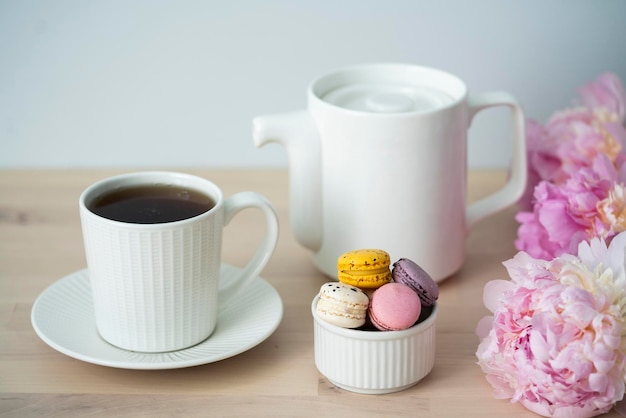 L'heure du thé Tasse de thé avec une théière et un macaron