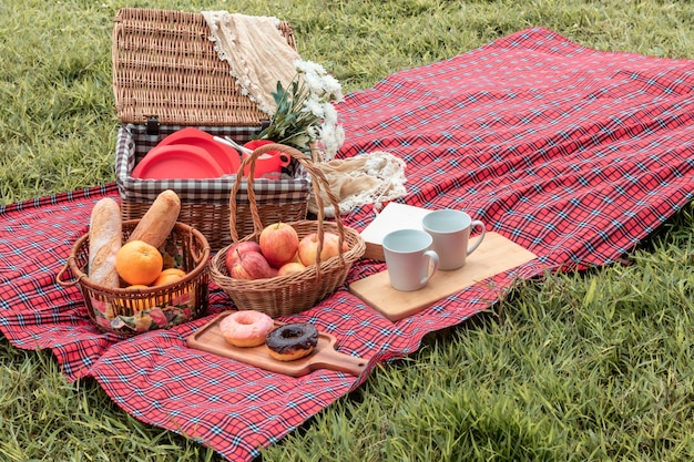 Photo heure d'été gros plan du panier de pique-nique avec de la nourriture et des fruits dans la nature.