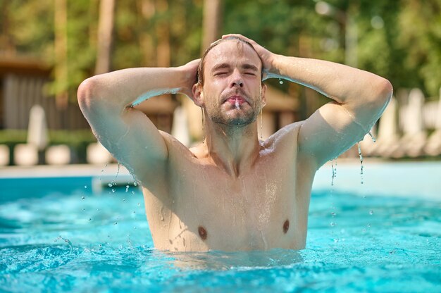 Heure d'été. Une photo d'un jeune bel homme dans une piscine