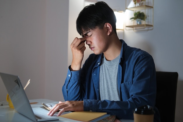 Les heures supplémentaires du jeune homme travaillent et se sentent fatigués.