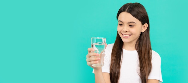 Heureuse adolescente boit un verre d'eau pour rester hydratée et maintenir l'équilibre hydrique quotidien Bannière d'enfant fille avec verre d'eau portrait en studio avec espace de copie