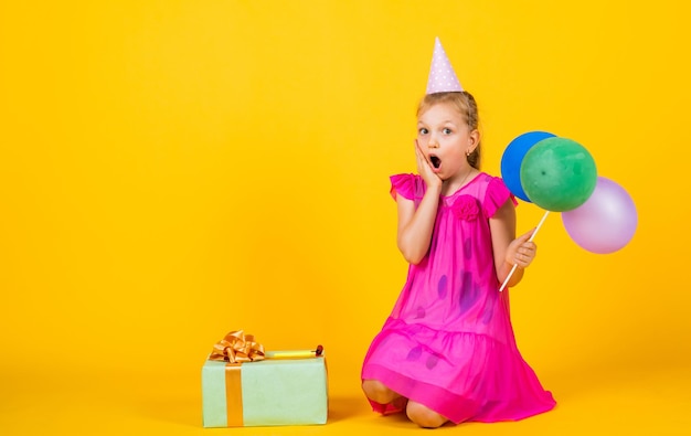 Heureuse adolescente avec boîte cadeau et ballons de fête bonheur de l'enfance