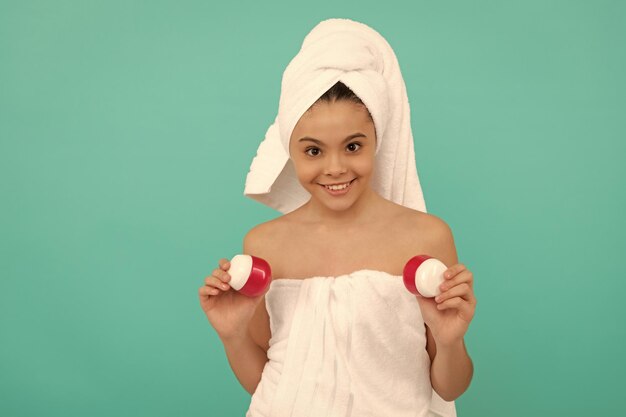 Heureuse adolescente dans la tour de bain présentant la beauté cosmétique du corps