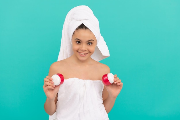 Heureuse adolescente dans la tour de bain présentant la beauté cosmétique du corps