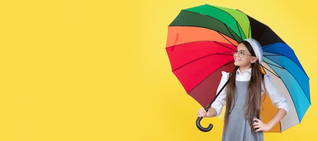 Heureuse adolescente sous un parapluie coloré pour la protection contre la pluie en automne Enfant avec parapluie d'automne bannière d'affiche horizontale temps pluvieux avec espace copie