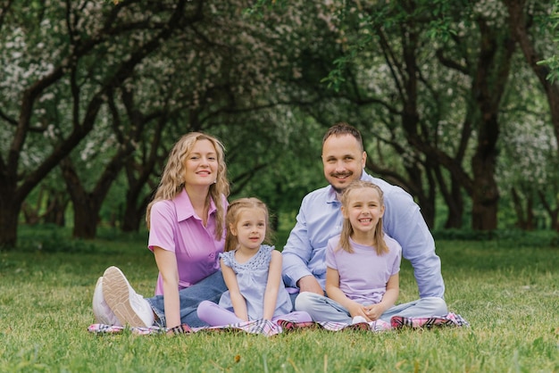 Heureuse belle famille assise sur la plage en été dans le parc