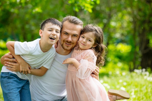 Heureuse belle famille ensemble père fils et fille portrait lors d'une promenade par une journée d'été ensoleillée