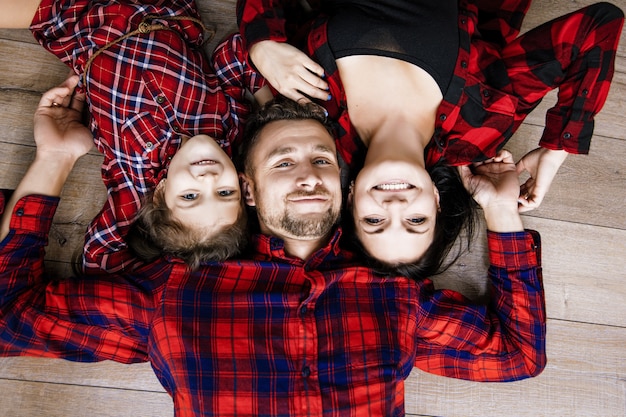 Heureuse belle famille heureuse ensemble à la maison allongé sur la vue de dessus de plancher en bois
