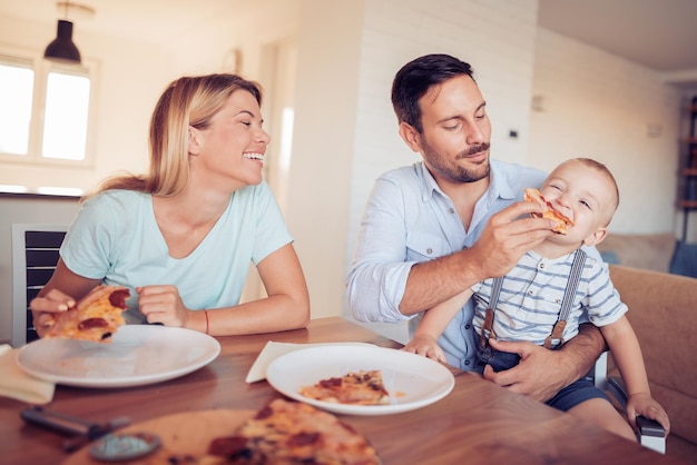 Heureuse belle famille mangeant de la pizza