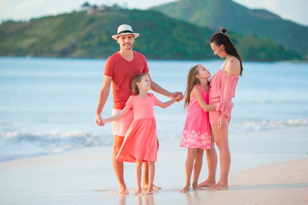 Heureuse belle famille sur la plage blanche