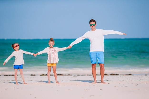 Heureuse belle famille en vacances à la plage tropicale