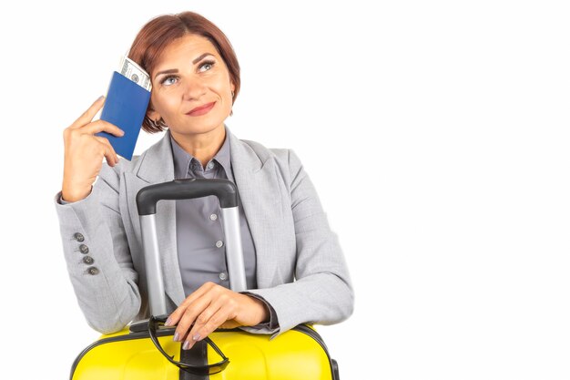 Heureuse belle femme d'affaires avec passeport et bagages partant en voyage. Vacances et divertissements. Recherchez des endroits où voyager.