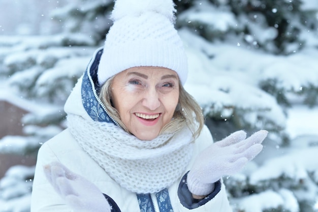 Heureuse belle femme âgée au chapeau chaud