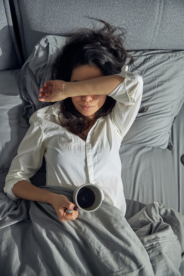 Photo heureuse belle femme asiatique tient une tasse et apprécie son café du matin