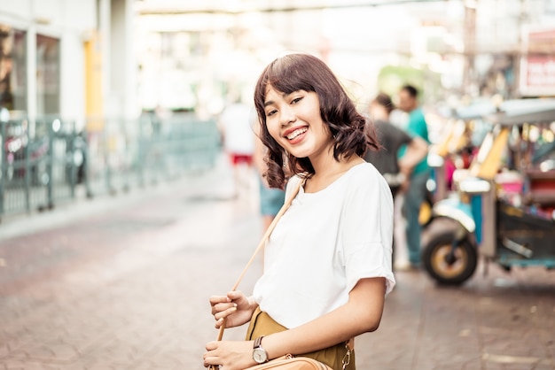 Heureuse et belle femme asiatique voyageant à Khao Sarn Road, Thailand