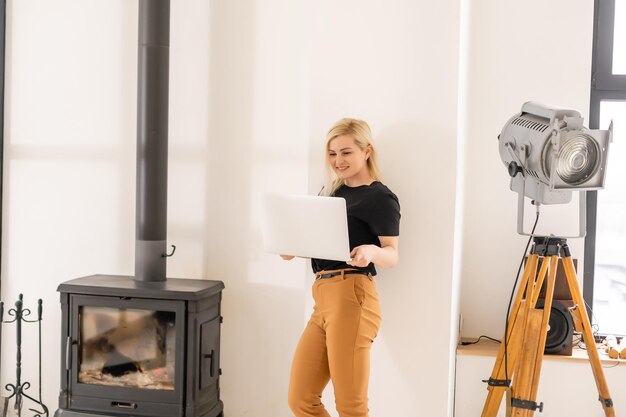 Heureuse belle femme décontractée travaillant sur un ordinateur portable assis dans la maison.