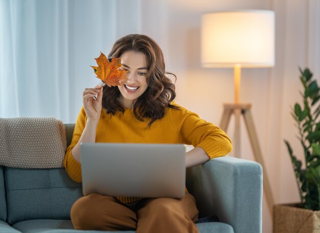 Heureuse belle femme décontractée utilisant un ordinateur portable à la maison.