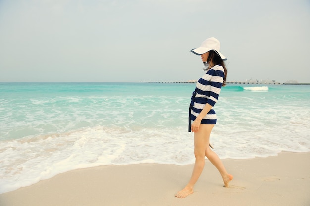 Heureuse belle femme profitant des vacances d'été sur la plage