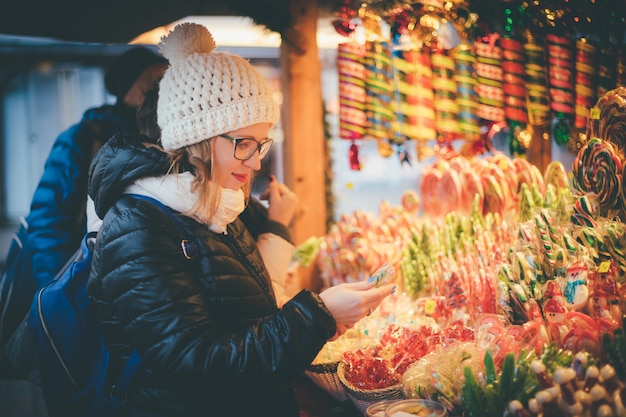 Photo heureuse belle femme sélectionnant des bonbons de vacances traditionnels