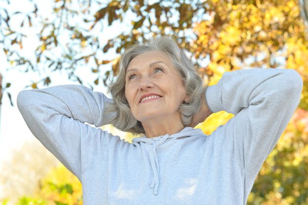 Heureuse belle femme senior dans le parc en automne