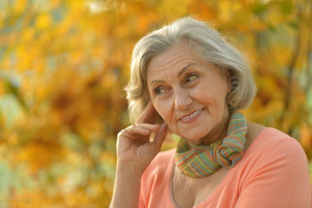 Heureuse belle femme senior dans le parc en automne