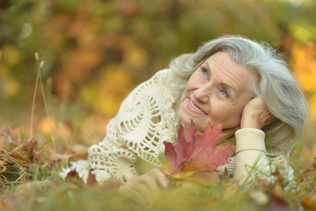 Heureuse belle femme senior dans le parc en automne