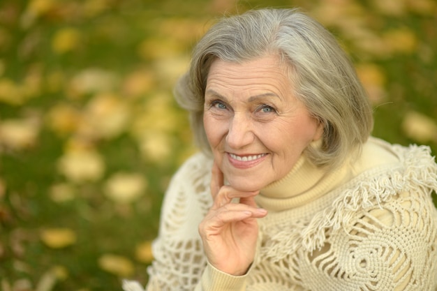 Heureuse belle femme senior dans le parc en automne