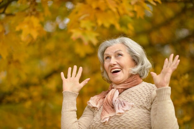 Heureuse belle femme senior dans le parc en automne